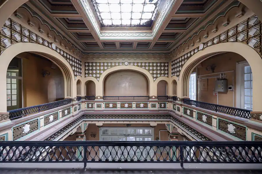 Central gallery of Casa Băileșteanu with decorative arches, ornate railings and a skylight ceiling